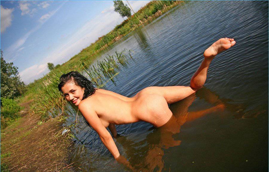 Худая жена на природе загорает голой у озера фото