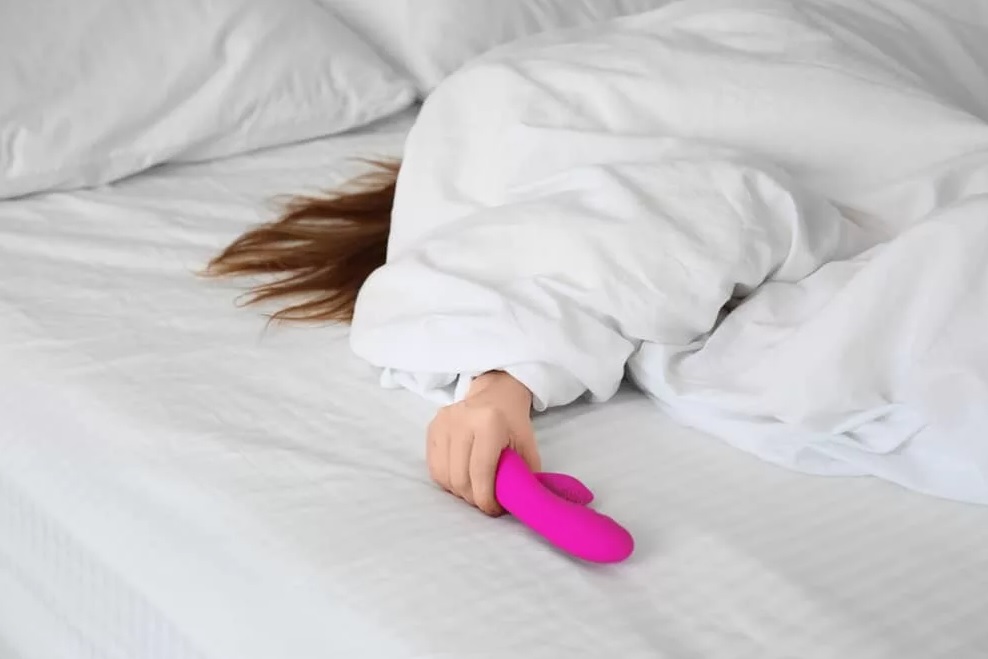 Девчонка мастурбирует фиолетовым дилдо лежа на кровати