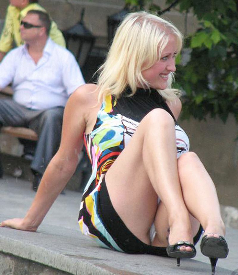 Блондинка показывает трусики под короткой черной юбкой 