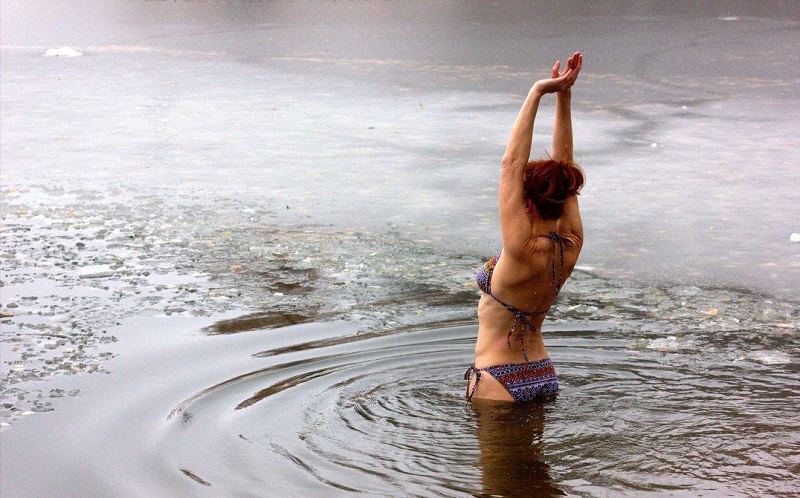 Загорелая голая девушка купается в реке