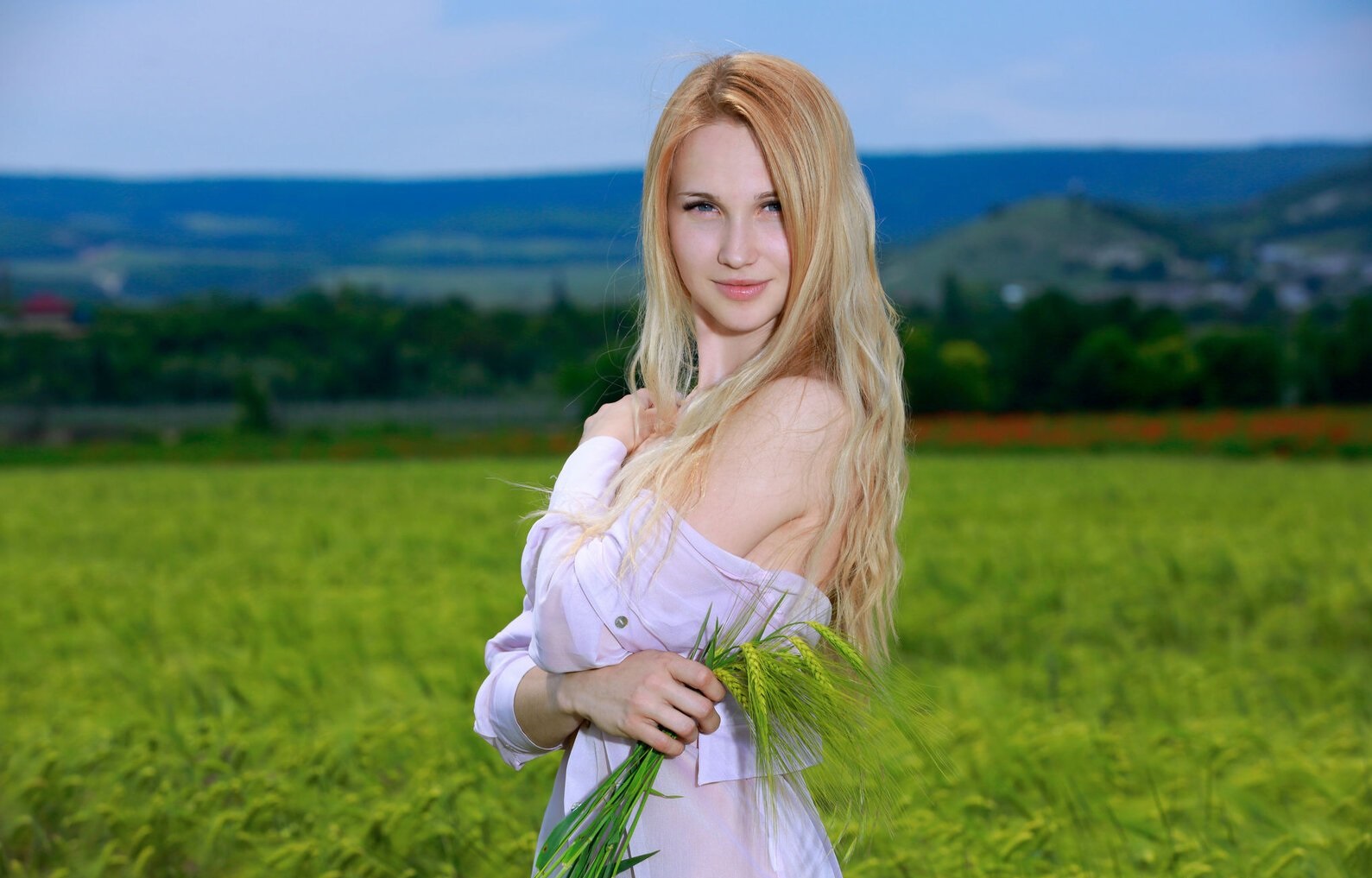 Голая девушка показывает свои прелести в поле